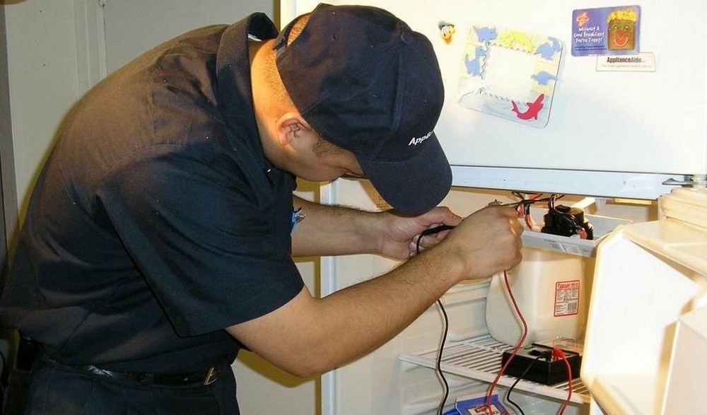 Мастер осматривает холодильник